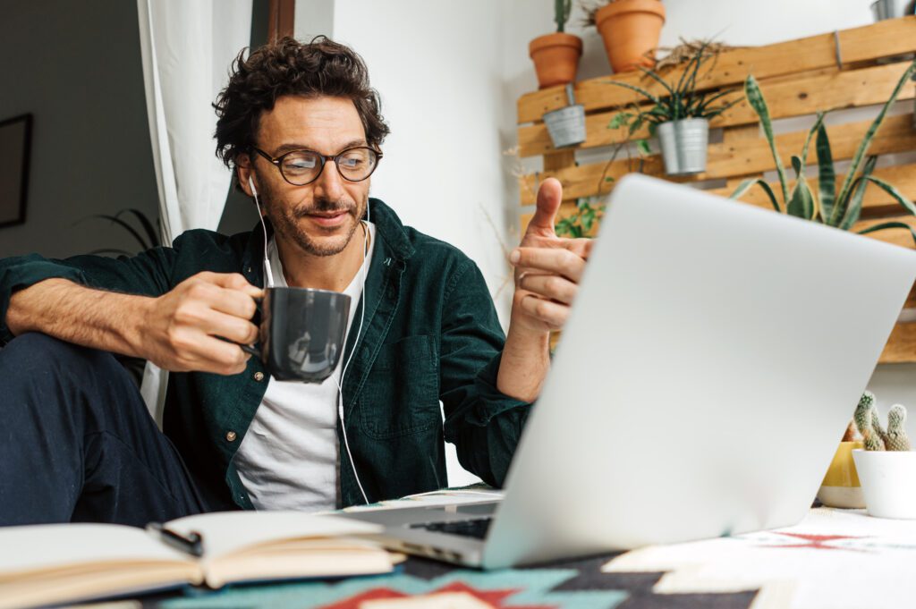 Man with laptop working remotely from home. Freelancer at remote work. Cozy workplace