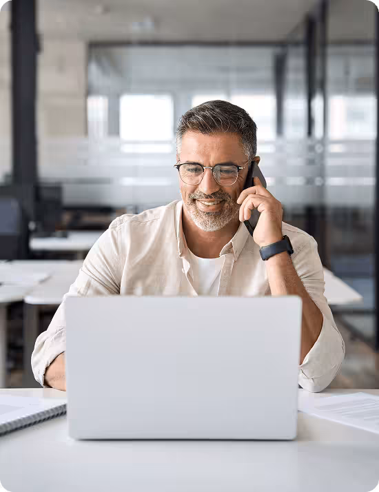 Business owner managing calls and communications from his laptop at the office