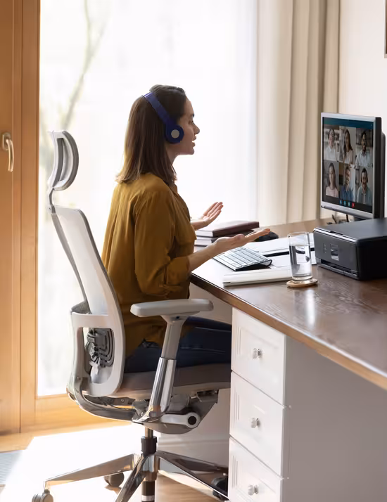 Remote team member on a video call, managing distributed team communications from a home office