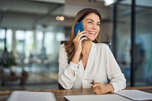 Happy business woman speaking on her mobile phone with a dedicated business phone number.
